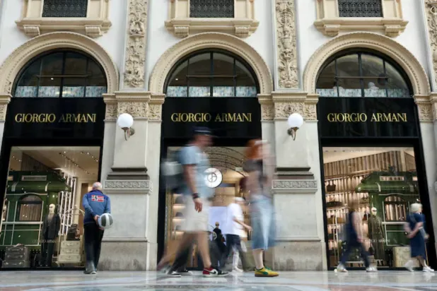 People walk past a Giorgio Armani store in Galleria Vittorio Emanuele II, following Giorgio Armani's death at the age of 91, in Milan, Italy, September 5, 2025. REUTERS/Gonzalo Fuentes/File Photo 