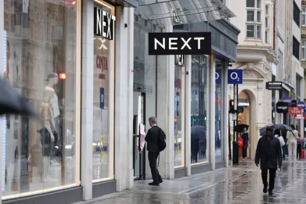 A shopper enters a Next store on Oxford Street in London, Britain, July 31, 2023. REUTERS/Hollie Adams/ File Photo