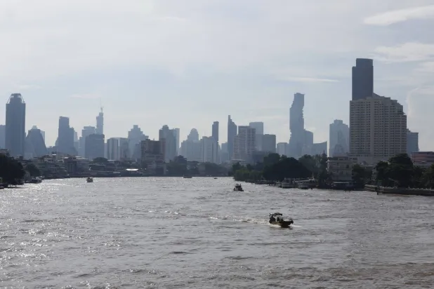 عمال أثناء جمع النفايات والأعشاب الضارة والقمامة من نهر تشاو فرايا في بانكوك (إ.ب.أ)