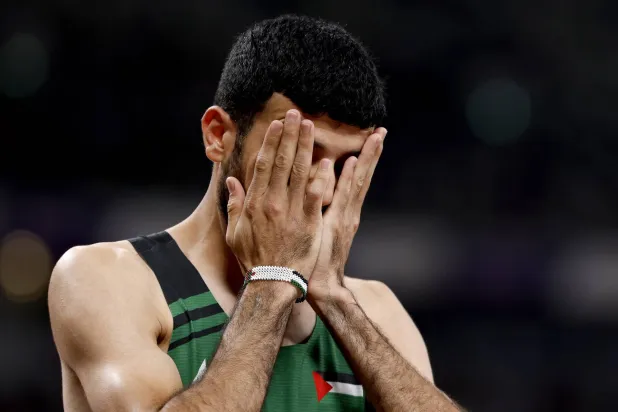 بدموع الحزن احتفل الفلسطيني محمد دويدار بإنهائه تصفيات سباق 800 متر رغم احتلاله المركز الأخير (إ.ب.أ)