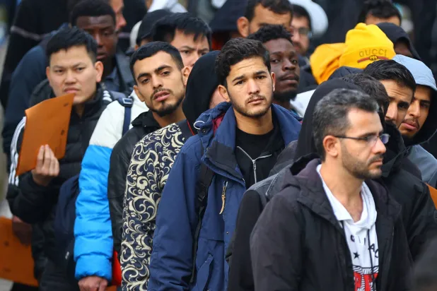 مهاجرون يقفون في طابور استعداداً للانتقال إلى مكتب التسجيل في مركز استقبال طالبي اللجوء بالعاصمة الألمانية برلين... 6 أكتوبر 2023 (رويترز)