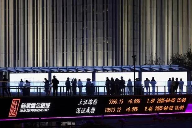 لوحة تعرض مؤشرات شنغهاي وشنتشن على جسر مشاة في حي لوجيازو المالي، شنغهاي (رويترز)