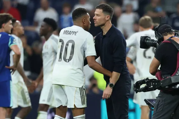 كيليان مبابي وهو يتحدث مع مدربه الإسباني تشابي ألونسو (أ.ف.ب)