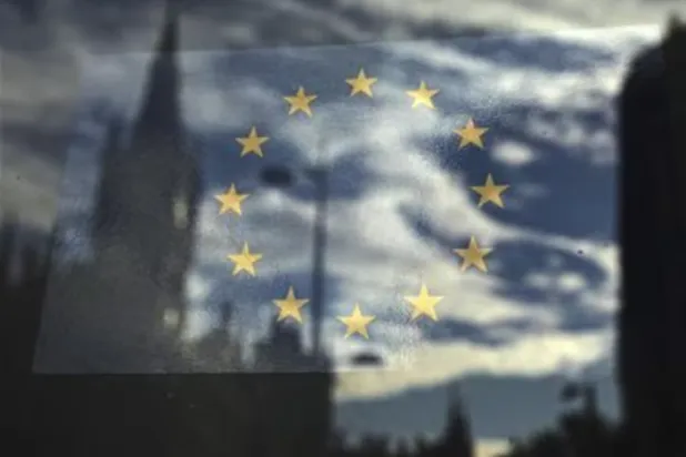 يُرى علم الاتحاد الأوروبي في نافذة تعكس شارعاً في لندن (رويترز)