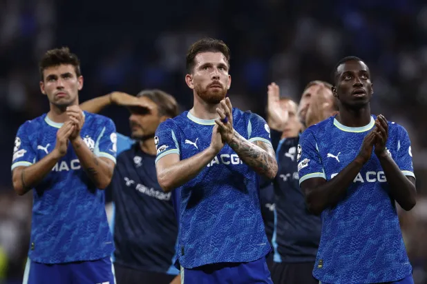 لاعبو أولمبيك مرسيليا يحيّون جماهيرهم بعد الخسارة في مباراة دوري أبطال أوروبا أمام الريال (إ.ب.أ)