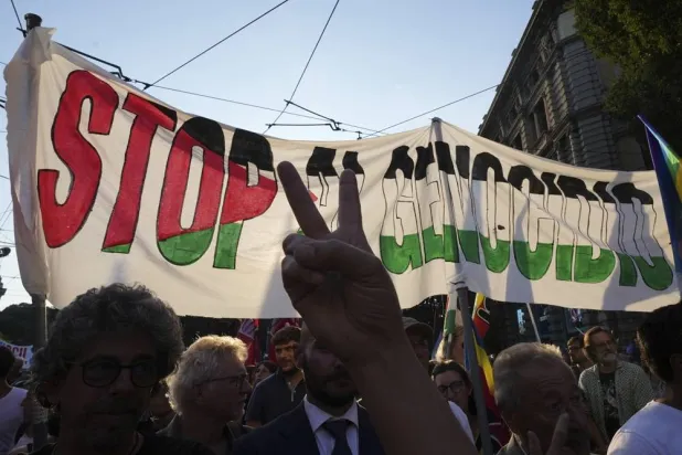  People hold a banner reading "Stop Genocide' as they take part in a demonstration in support of Palestinians in Milan, Italy, Friday, Sept. 19, 2025. (AP)