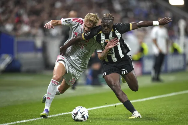 آدم كارابيك لاعب ليون يتنافس على الكرة مع جاك إيكومي من أنجيه (أ.ب)