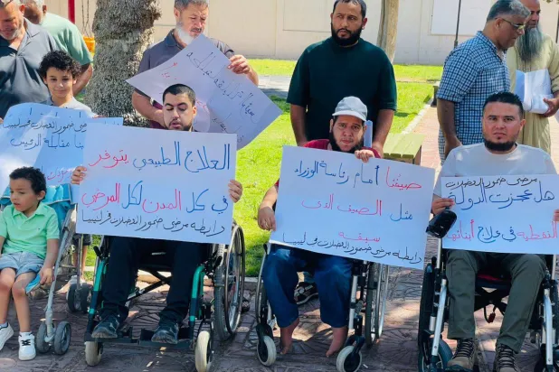 مصابون بمرض ضمور العضلات خلال وقفة احتجاجية أمام مقر الحكومة في طرابلس أخيراً (رابطة ضمور العضلات)
