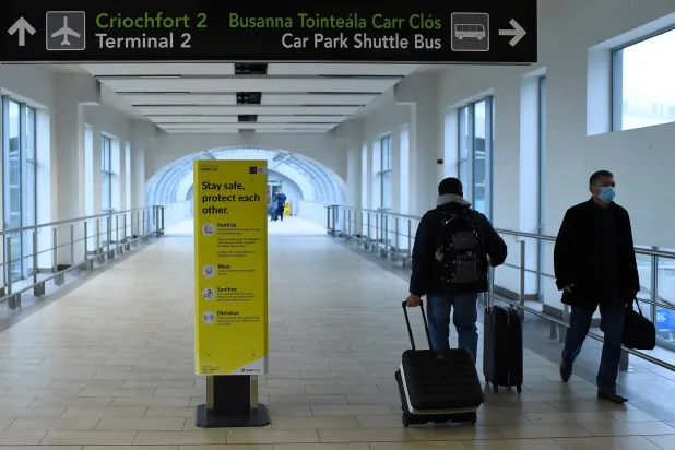 مسافران يسيران في مبنى الركاب رقم 2 بمطار دبلن (رويترز)