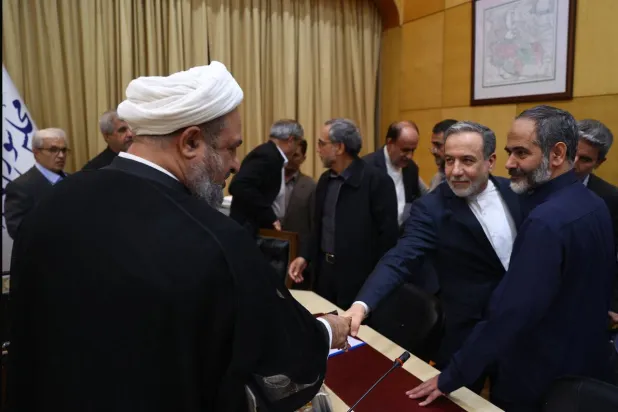 وزير الخارجية الإيراني عباس عراقجي يصافح النائب المتشدد حميد رضا رسائي على هامش اجتماع مشترك الأسبوع الماضي (أرشيفية - البرلمان الإيراني)