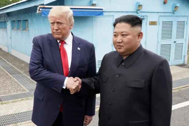 الزعيم الكوري الشمالي كيم جونغ أون (يمين) يصافح الرئيس الأميركي دونالد ترمب (أرشيفية - رويترز)