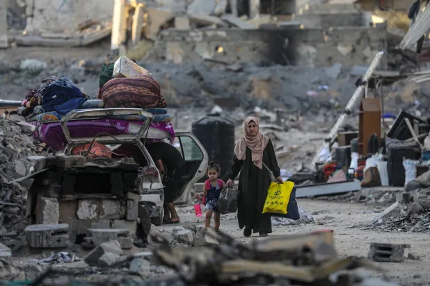 فلسطينيون نازحون داخلياً يخلون منطقة استهدفتها غارة جوية إسرائيلية في مدينة غزة (إ.ب.أ)