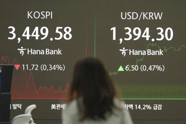 متداولة تراقب شاشات تعرض مؤشر «كوسبي» وسعر صرف الدولار مقابل الوون في بنك «هانا» بسيول (أ.ب)