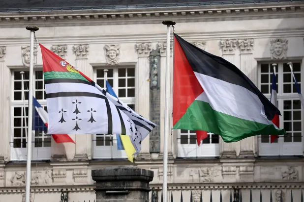 العلم الفلسطيني يرفرف بجوار علم مدينة نانت أمام مبنى البلدية في فرنسا (رويترز)