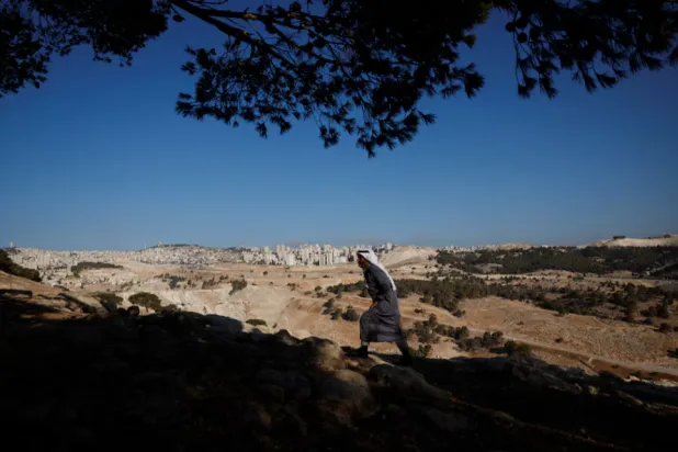 A Palestinian Bedouin walks up a hill, as the communities of Jabal Al-Baba faces displacement due to plans to build a new Israeli settlement near the E1 road, in Jabal Al-Baba in the Israeli-occupied West Bank, September 17, 2025. REUTERS/Ammar Awad 