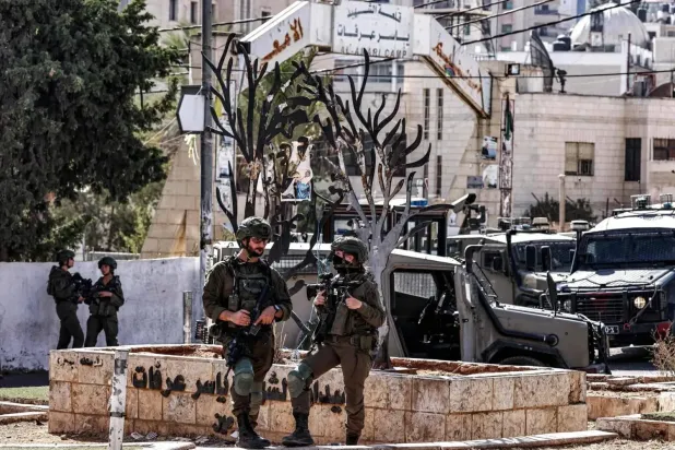 Batı Şeria'nın Ramallah kentindeki el-Emari Mülteci Kampı’nın girişinde konuşlanan İsrail askerleri (Arşiv – AFP)