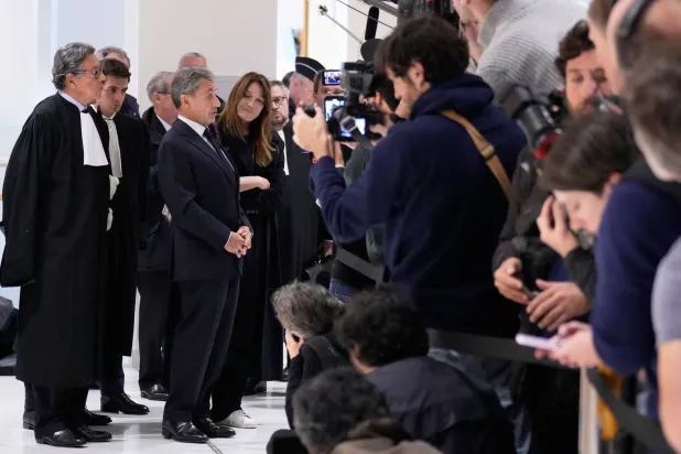 الرئيس الأسبق نيكولا ساركوزي متحدثاً للصحافة وإلى جانبه زوجته ومحاموه بعد انتهاء جلسة إصدار الحكم في باريس يوم 25 سبتمبر (إ.ب.أ)