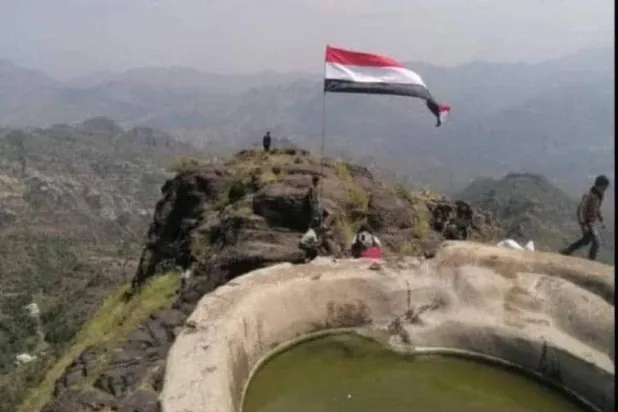 شبان في ريف محافظة إب يرفعون العلم الجمهوري قرب خزان مائي (إكس)