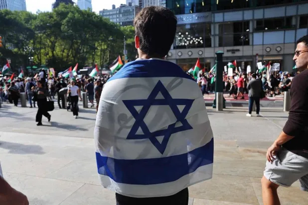 A man holds an Israeli flag as Pro-Palestinian protesters march through Manhattan near the United Nations as Israeli Prime Minister Benjamin Netanyahu addresses the United Nations (UN) General Assembly during the 80th session of the annual event on September 26, 2025, in New York. (Getty Images/AFP)