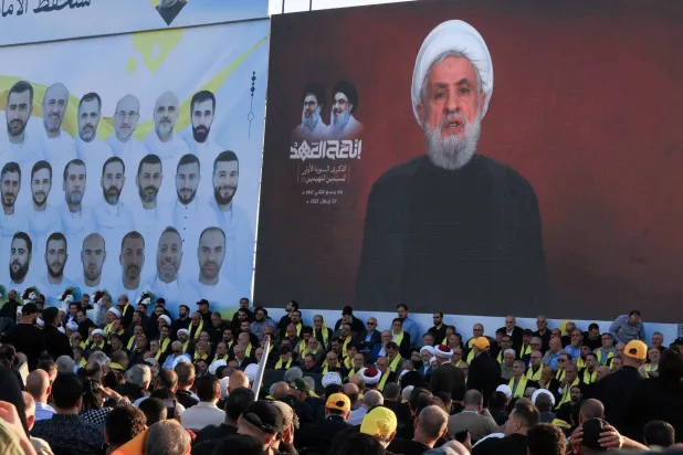 الأمين العام لـ«حزب الله» نعيم قاسم يلقي كلمة عبر الشاشة في الاحتفال (رويترز)