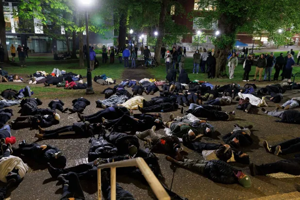 طلاب مؤيدون للفلسطينيين يستلْقون على الأرض في أثناء تظاهرهم في حرم جامعة ولاية بورتلاند في أوريغون 1 مايو (أ.ف.ب)