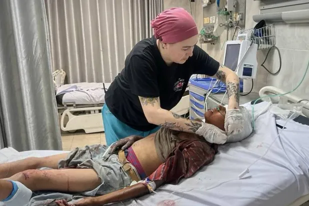 This photo provided by American nurse Andee Vaughan, shows Vaughan attending to a wounded child at the Al-Quds Hospital in Gaza City on Aug. 10, 2025. (Courtesy Andee Vaughan via AP) 
