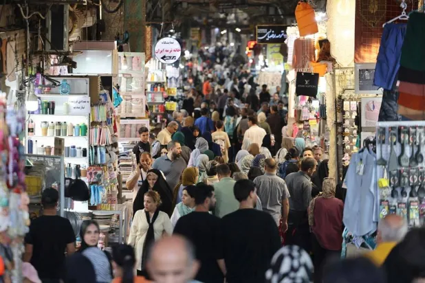 Iranians walk past shops at the Grand Bazaar in Tehran on September 27, 2025. (AFP)