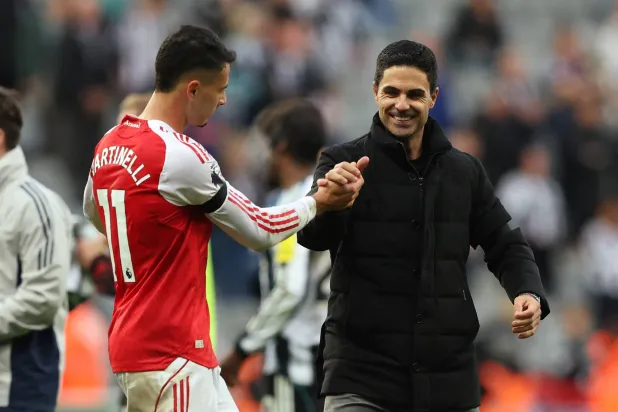 الإسباني ميكيل أرتيتا مدرب آرسنال يحتفل مع لاعبه غابرييل مارتينيلي (رويترز) 
