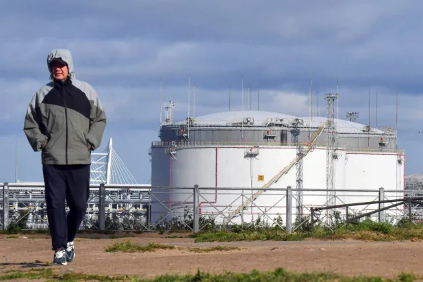 رجل يمر بمحطة النفط في ميناء سانت بطرسبرغ (أ.ف.ب)