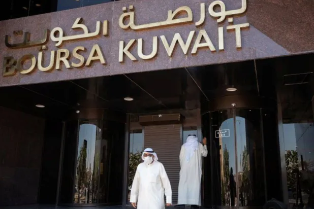 رجل يرتدي قناعاً واقياً أمام بورصة الكويت (أرشيفية - رويترز)