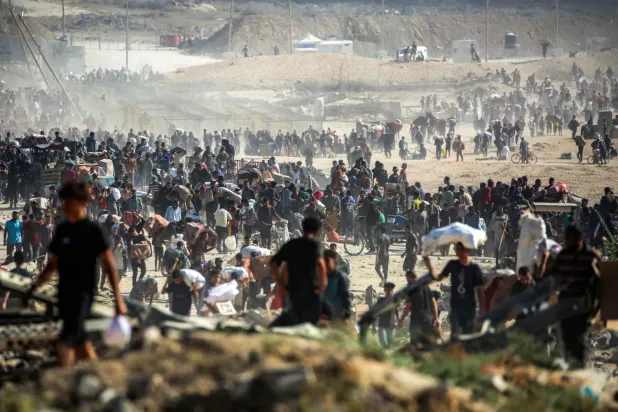 Dün Gazze Şeridi'nin orta kesimlerindeki Nuseyrat Mülteci Kampı’nda ABD ve İsrail destekli Gazze İnsani Yardım Vakfı tarafından işletilen bir merkezden aldıkları insani yardımları taşıyan Filistinliler (AFP)