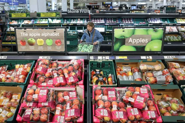 التفاح والفواكه الطازجة تُعرض للبيع داخل متجر في بريطانيا (رويترز)
