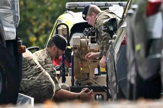 جنديان يشتغلان على جهاز لتفكيك القنابل قرب موقع الهجوم في مانشستر أمس (أ.ف.ب)
