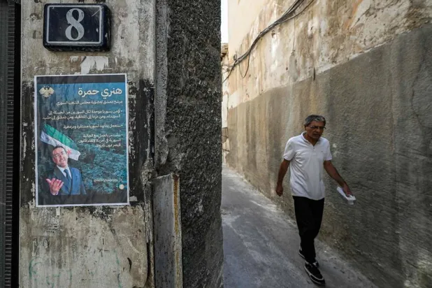 An election poster of Henry Hamra, a Syrian-American parliamentary candidate who is the son of the country's last rabbi and who if elected will be the first Jewish representative in the Syrian parliament since the late 1940s, is displayed on the entrance of the closed Jewish Maimonides School of Damascus, in the Jewish quarter of the old city of Damascus on October 3, 2025, ahead of the upcoming vote on October 5. (AFP)