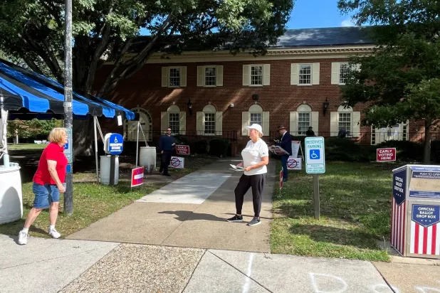 متطوعون يشجعون الناخبين على الإدلاء بأصواتهم في فيرجينيا يوم 2 أكتوبر (رويترز)