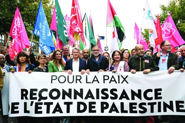 فرنسيون يرفعون لافتة كُتب عليها: «من أجل السلام... الاعتراف بدولة فلسطين» خلال مسيرة في باريس أمس (أ.ف.ب)