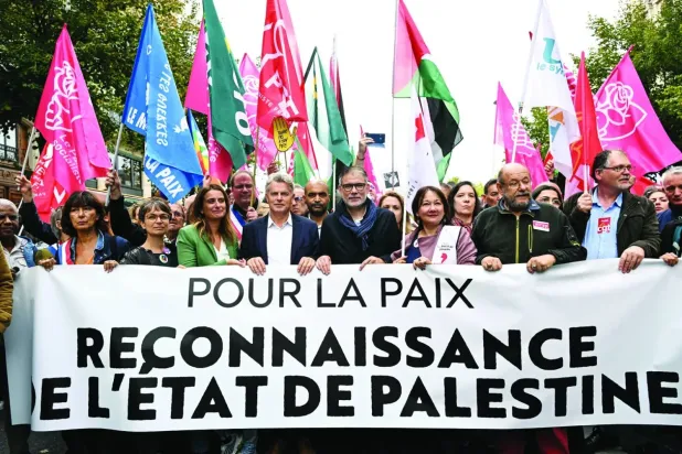 Paris'te dün düzenlenen yürüyüşte ‘Barış için Filistin devletini tanıyın’ yazılı bir pankart taşıyan Fransızlar (AFP)