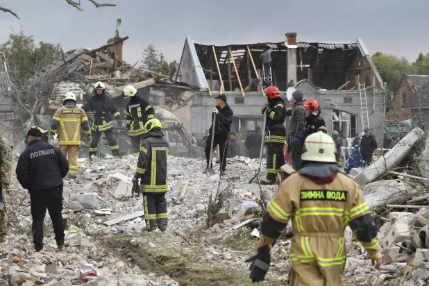 عاملو إنقاذ يعملون في موقع استهدفه قصف روسي على مدينة لفيف يوم 5 أكتوبر (إ.ب.أ)