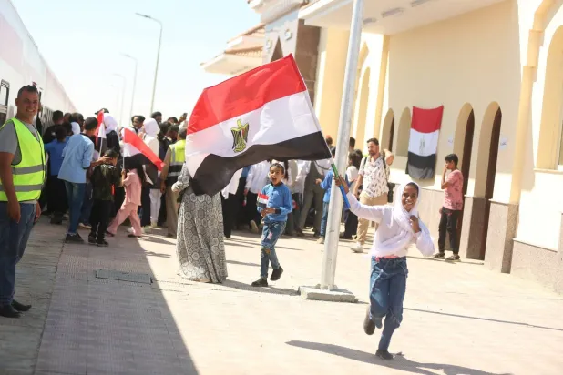 فتاة من أهالي بئر العبد في سيناء ترفع علم مصر فرحة بعودة خط قطار إلى العمل بعد نصف قرن من توقفه (مجلس الوزراء المصري)