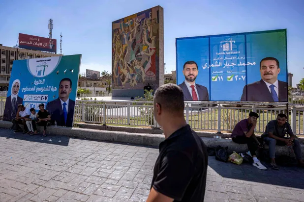 ملصقات انتخابية في بغداد أحدها لرئيس الوزراء محمد شياع السوداني (أ.ف.ب)