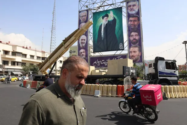 An Iranian Kheibar-Shekan medium-range ballistic missile (MRBM) placed next to a large banner depicting Iranian Supreme Leader Ali Khamenei (C) in Baharestan Square in Tehran, Iran, 27 September 2025. EPA/ABEDIN TAHERKENAREH