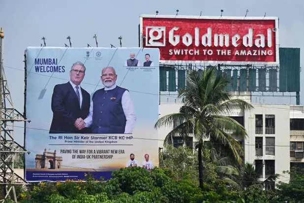 لوحة إعلانية تعرض صورة لرئيس الوزراء الهندي مرحباً بنظيره البريطاني بأحد شوارع مومباي يوم 8 أكتوبر 2025 (أ.ف.ب)