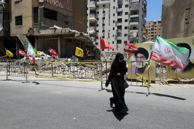 Hezbollah supporter marches near previously Israeli-struck site in Beirut suburb (EPA)  