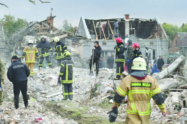 عاملو إنقاذ يعملون في موقع استهدفه قصف روسي على مدينة لفيف يوم 5 أكتوبر (إ.ب.أ)