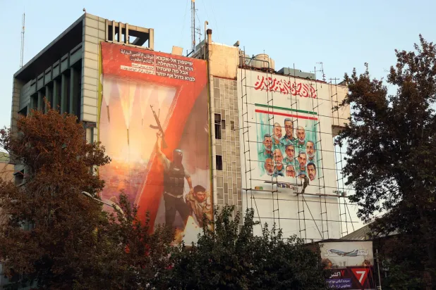 لافتة تحمل صورة قادة إيرانيين قُتلوا في الحرب الأخيرة وأخرى مناهضة لإسرائيل فوق مركز إعلامي معني بفلسطين وسط طهران (إ.ب.أ)