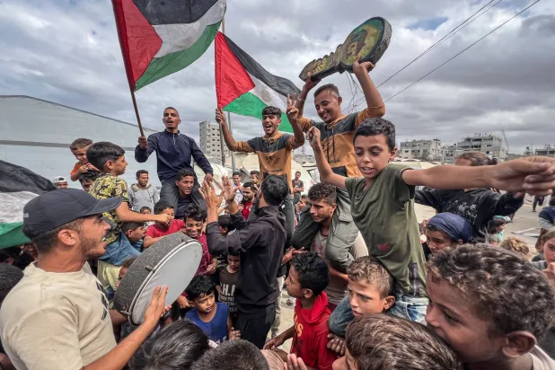 فلسطينيون يحتفلون في مخيم النصيرات بغزة أمس باتفاق وقف النار (د.ب.) وفي الإطار احتفالات أخرى في تل أبيب بنفس المناسبة (رويترز)
