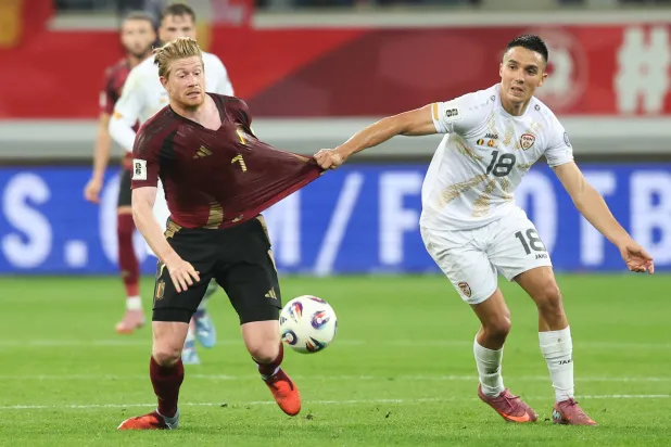 دي بروين يحاول الوصول إلى الكرة وسط مضايقة المقدوني بابونسكي (د.ب.أ)