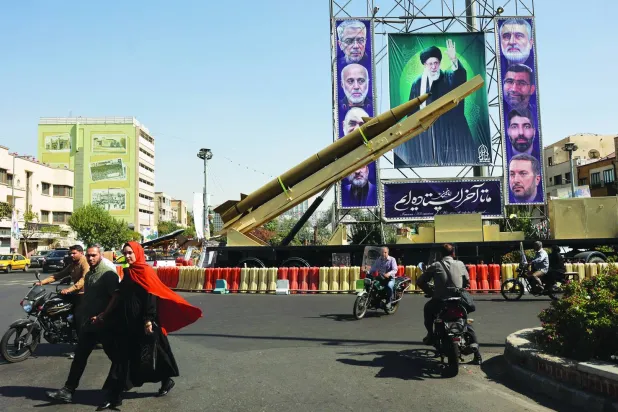 An Iranian missile system is displayed next to a banner with a picture of Iran's Supreme Leader Ali Khamenei during the Iranian Defense Week, in a street in Tehran, Iran, September 25, 2025. Majid Asgaripour/WANA (West Asia News Agency) via REUTERS  