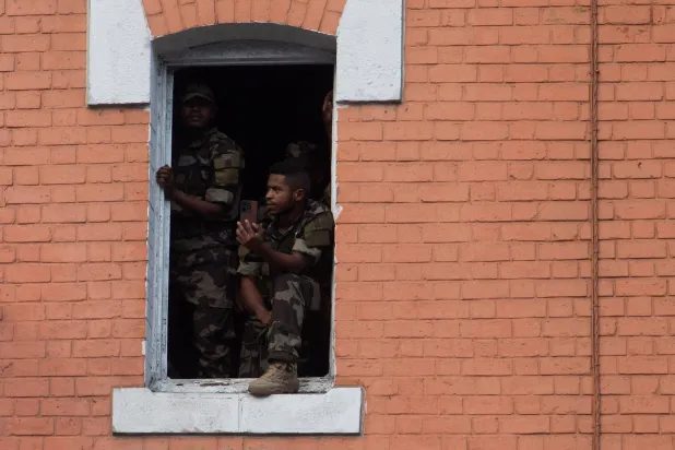 جنود من جيش مدغشقر يشاهدون المظاهرات ضد انقطاع المياه والكهرباء في العاصمة أنتاناناريفو (رويترز) 