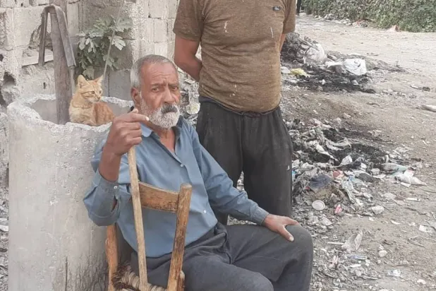 رجل من حي الدخانية شرقي دمشق يجلس على طريق رئيسي ينفتح على عدد قليل من الجادات التي نجت من الدمار (الشرق الأوسط)